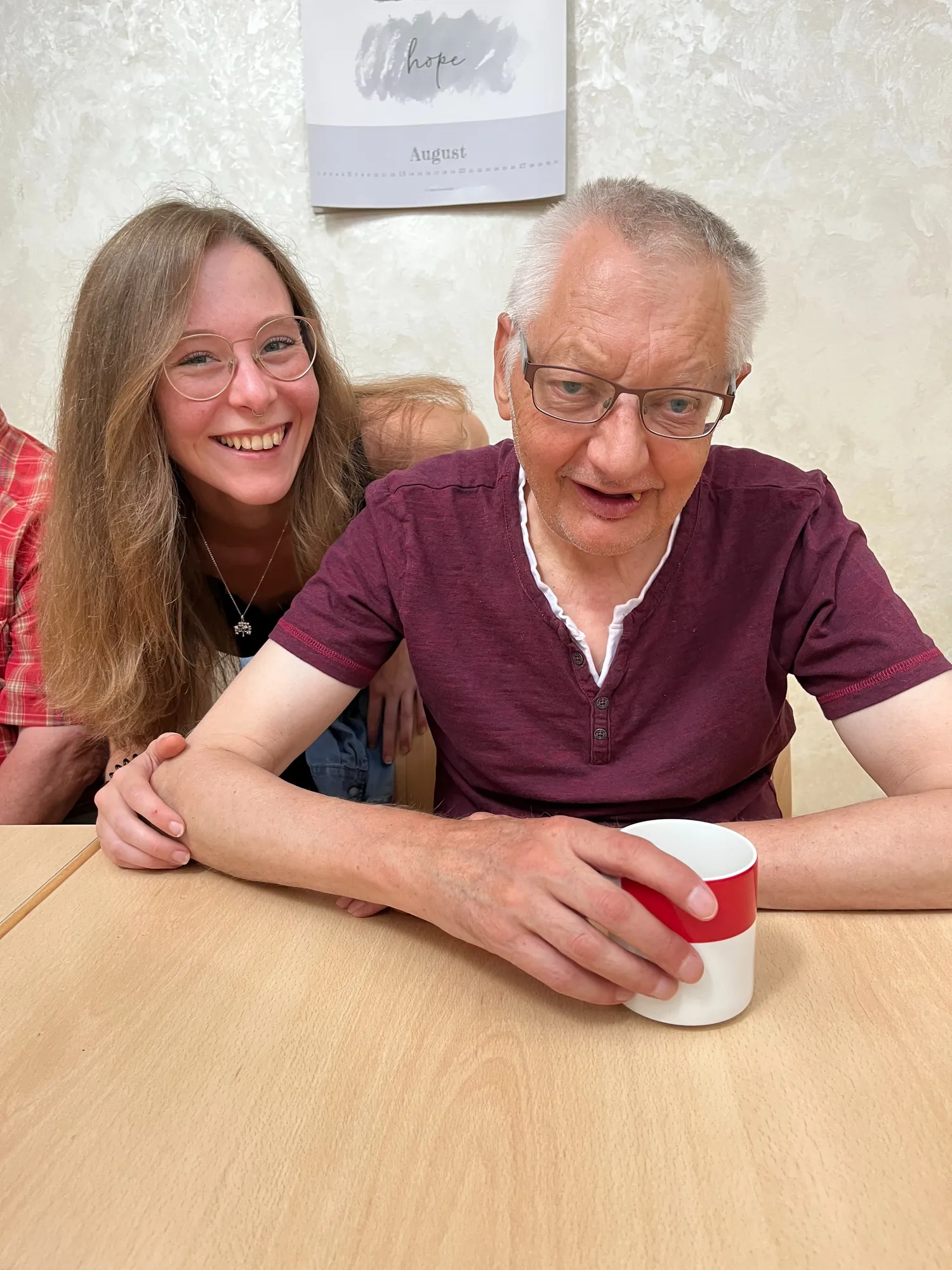 Vater und Tochter trinken Kaffee am Tisch, lächeln in gemütlicher Küche.