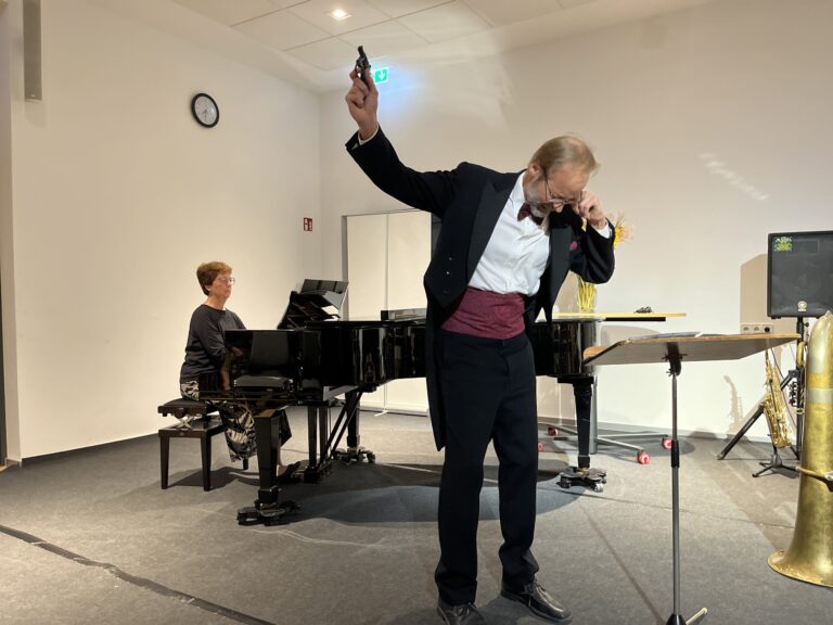 Andreas Balzer in Frack bei Klavierabend, begleitet von Regina Zimmermann-Emde am Flügel.