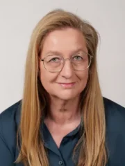 Professionelles Porträt von Annette Tross, blonde Frau mit Brille im Business-Outfit.