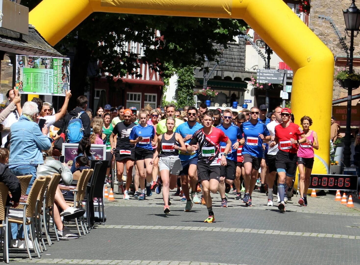 Start beim Charity Walk & Run: Läufer starten unter gelbem Torbogen in Altstadt.