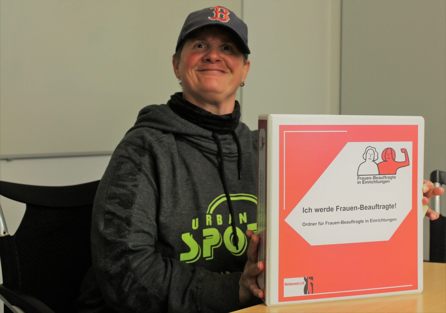 Corinna Hast zeigt Ordner für Frauenbeauftragte in Werkstätten, steht für Mitbestimmung und Gleichstellung.