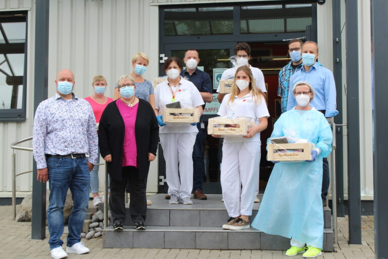Lebenshilfe Dillenburg überreicht Genusskörbe an DRK-Impfteam vor Impfzentrum, Gruppenfoto mit Masken