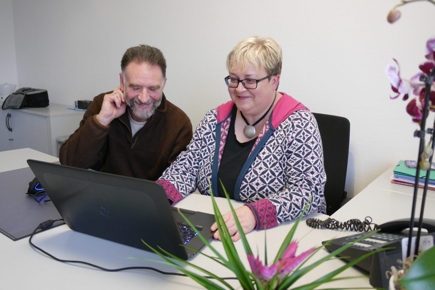 Einarbeitung und Übergabe: Andreas Thamer und Tanja Rockensüß arbeiten gemeinsam am Laptop im Büro.
