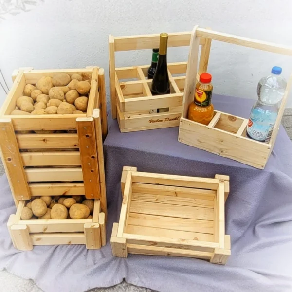 Rustikale Kiefernholz-Kisten und Flaschenträger mit Kartoffeln und Getränkeflaschen auf Stoff