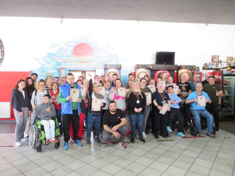 Gruppenfoto beim inklusiven Dart-Turnier in Herborn mit Urkunden und Medaillen.