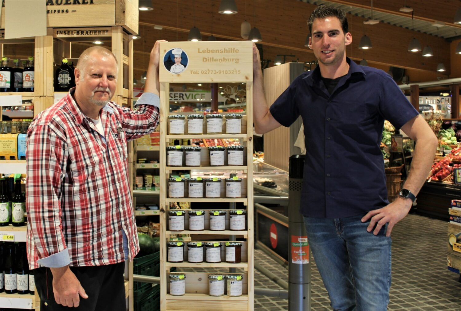 Jörg Bastian und Robin Rohn präsentieren Lebenshilfe Dillenburg Marmeladenregal bei Edeka-Mitsch.