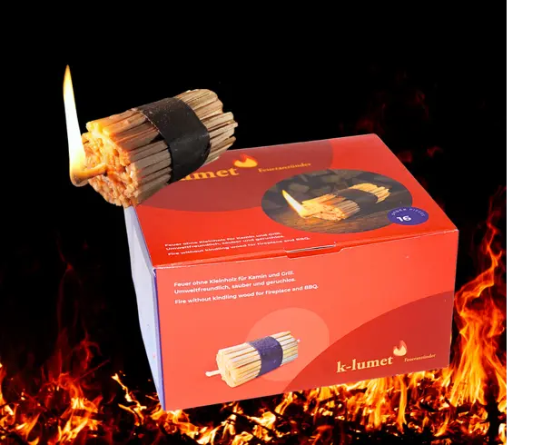 K-Lumet Öko-Feueranzünder für Kamin und Grill, brennender Anzündstick vor Flammen.