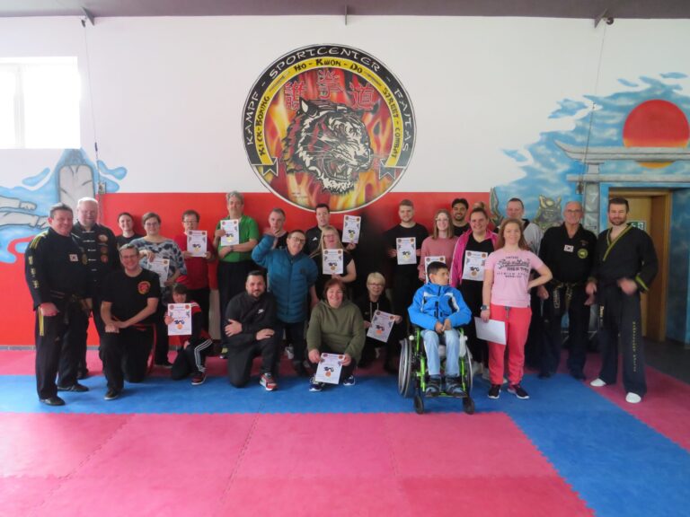 Inklusive Karategruppe im Kampfsportcenter hält Urkunden nach Schnuppertraining, Rollstuhlfahrer vorne.