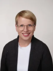 Professionelles Porträt von Karin Schill, blonde Frau mit Brille, Business-Headshot.