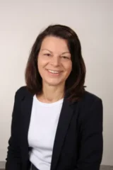 Professionelles Business-Porträt von Kerstin Lotz im Blazer vor neutralem Hintergrund.