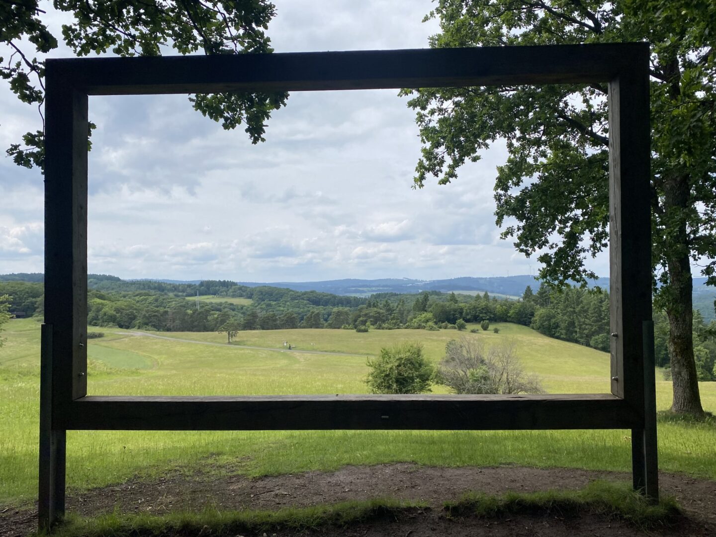 Aussichtsrahmen am Kornberg mit Panoramablick über grüne Wiesen und Hügel.