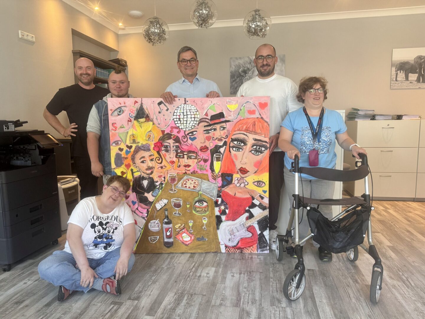 Kanzlei-Team übergibt Christoph Heinigk ein buntes Gemälde, Gruppenfoto mit Künstlerinnen und Künstlern.