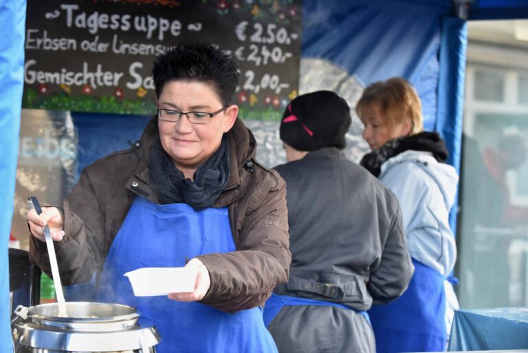 Frau serviert Tagessuppe am Lebenshilfe-Suppenstand auf dem Wochenmarkt Haiger.