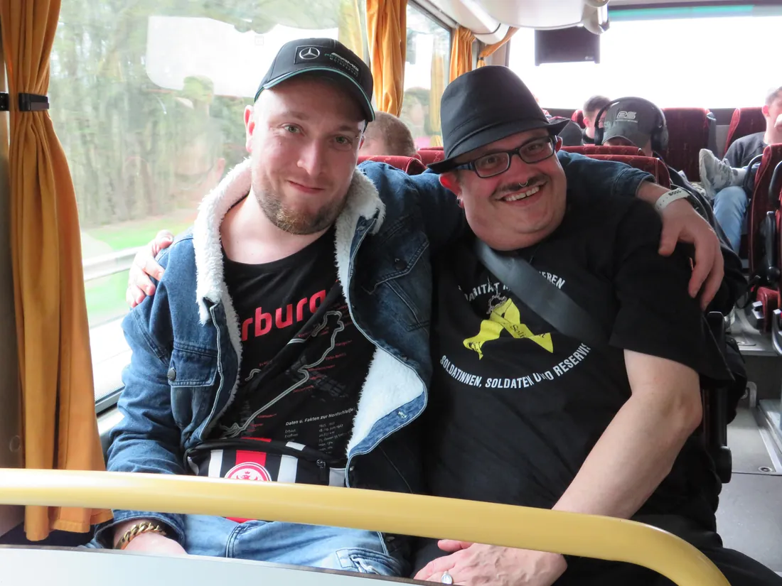Zwei lachende Freunde machen ein Selfie im Reisebus auf Ausflugstour.