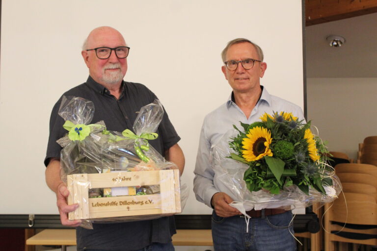 Michael Koch überreicht Jürgen Raab Blumenstrauß und Präsent bei Verabschiedung.