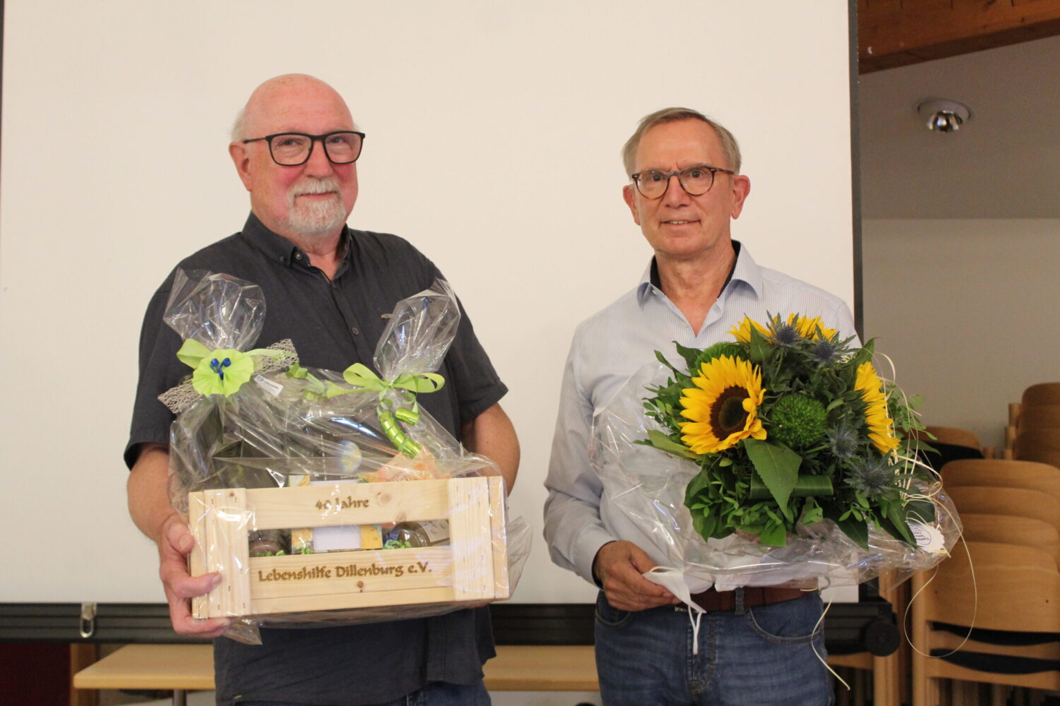 Michael Koch überreicht Jürgen Raab Blumenstrauß und Präsent bei Verabschiedung.