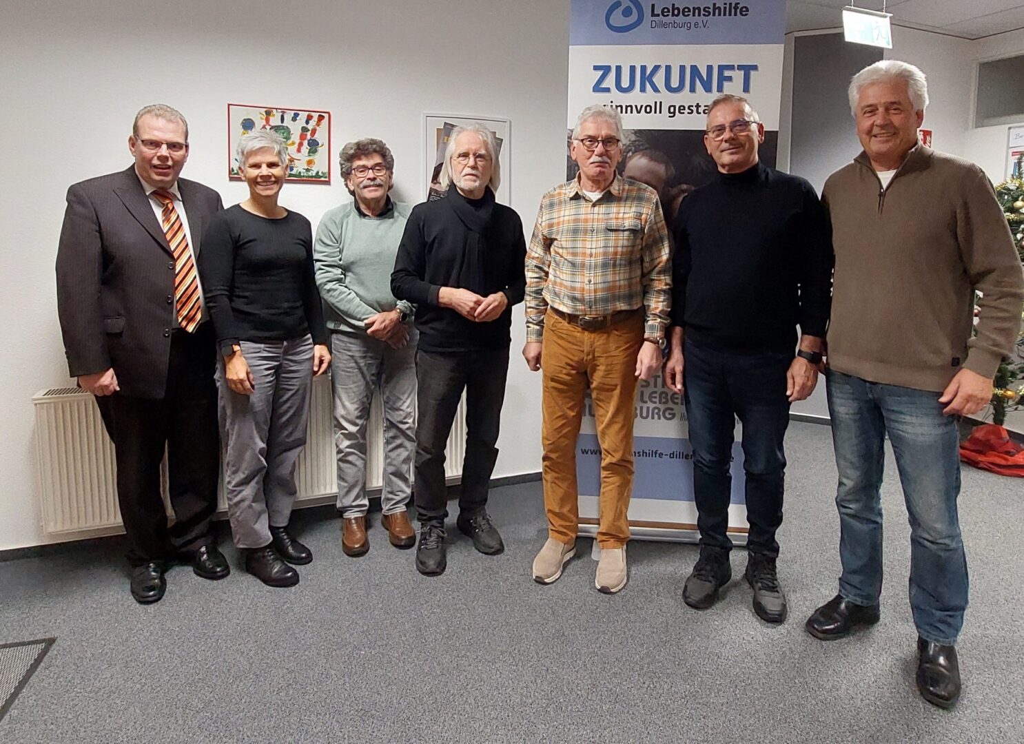 Neuer Vorstand und Stiftungsrat der Lebenshilfe Dillenburg e.V. posieren vor Zukunfts-Banner.