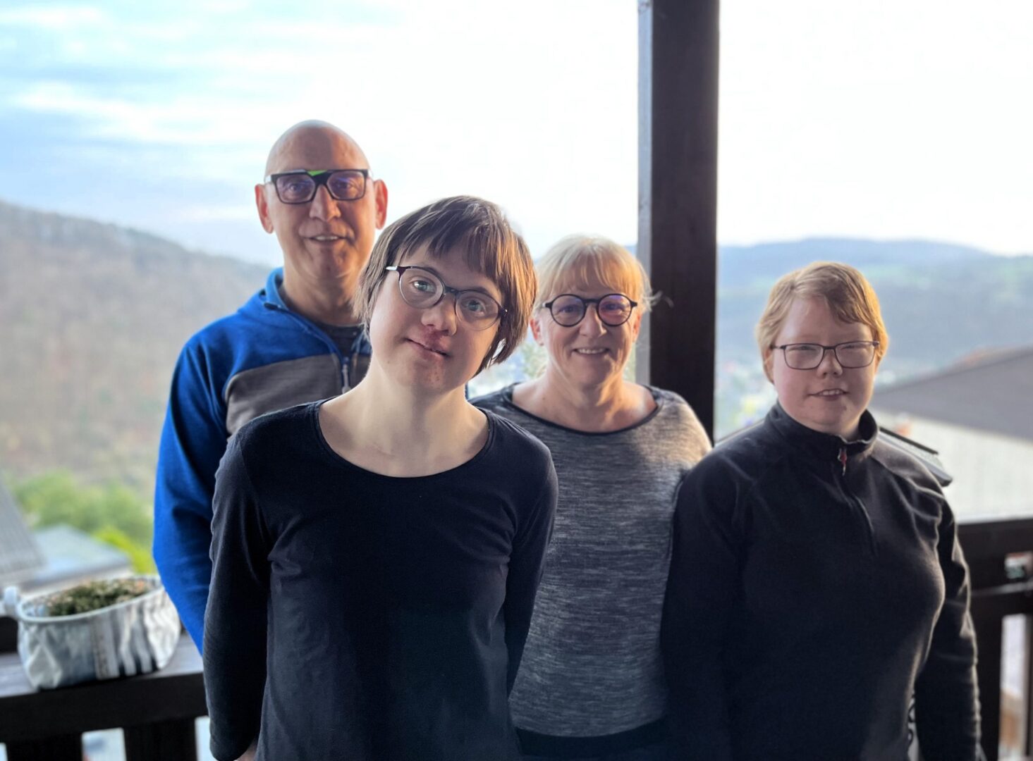 Pflegefamilie auf dem Balkon in den Bergen: Luisa mit Pflegeeltern und Pflegeschwester.
