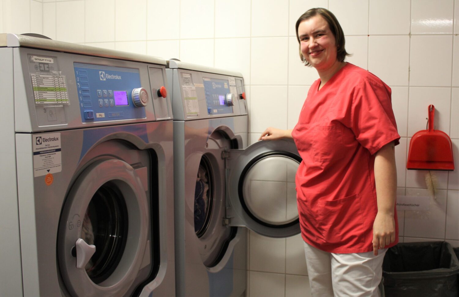 Pflegekraft in der Wäscherei bedient Electrolux Industriewaschmaschinen im DRK-Seniorenzentrum
