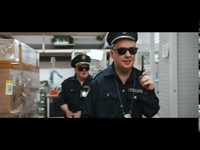 Zwei Polizeibeamte in Uniform und Sonnenbrille im Lager, Walkie-Talkie im Einsatz.