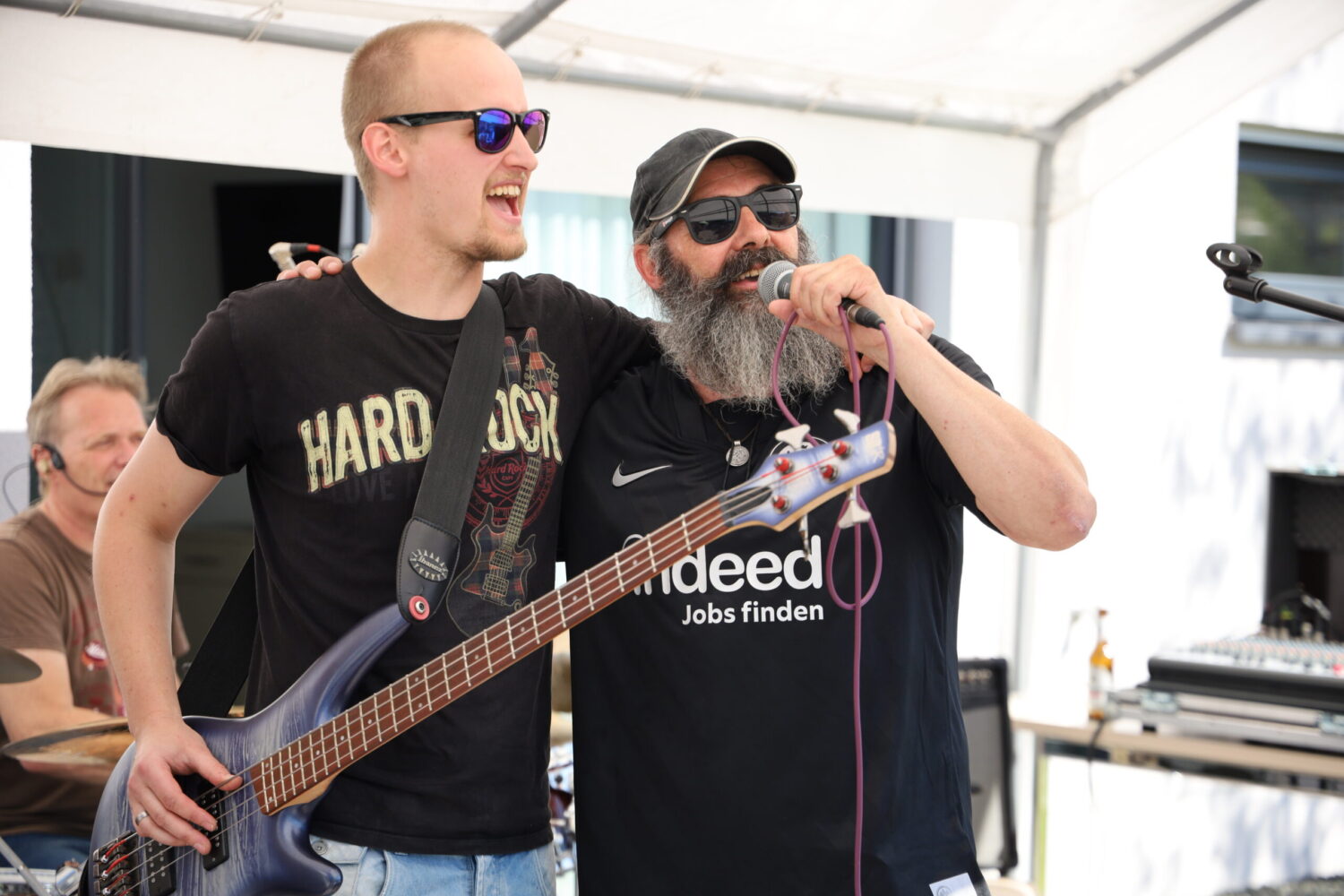 Roadie-Band in Haiger: Bassist und Sänger jubeln beim Auftritt unter dem Pavillon.