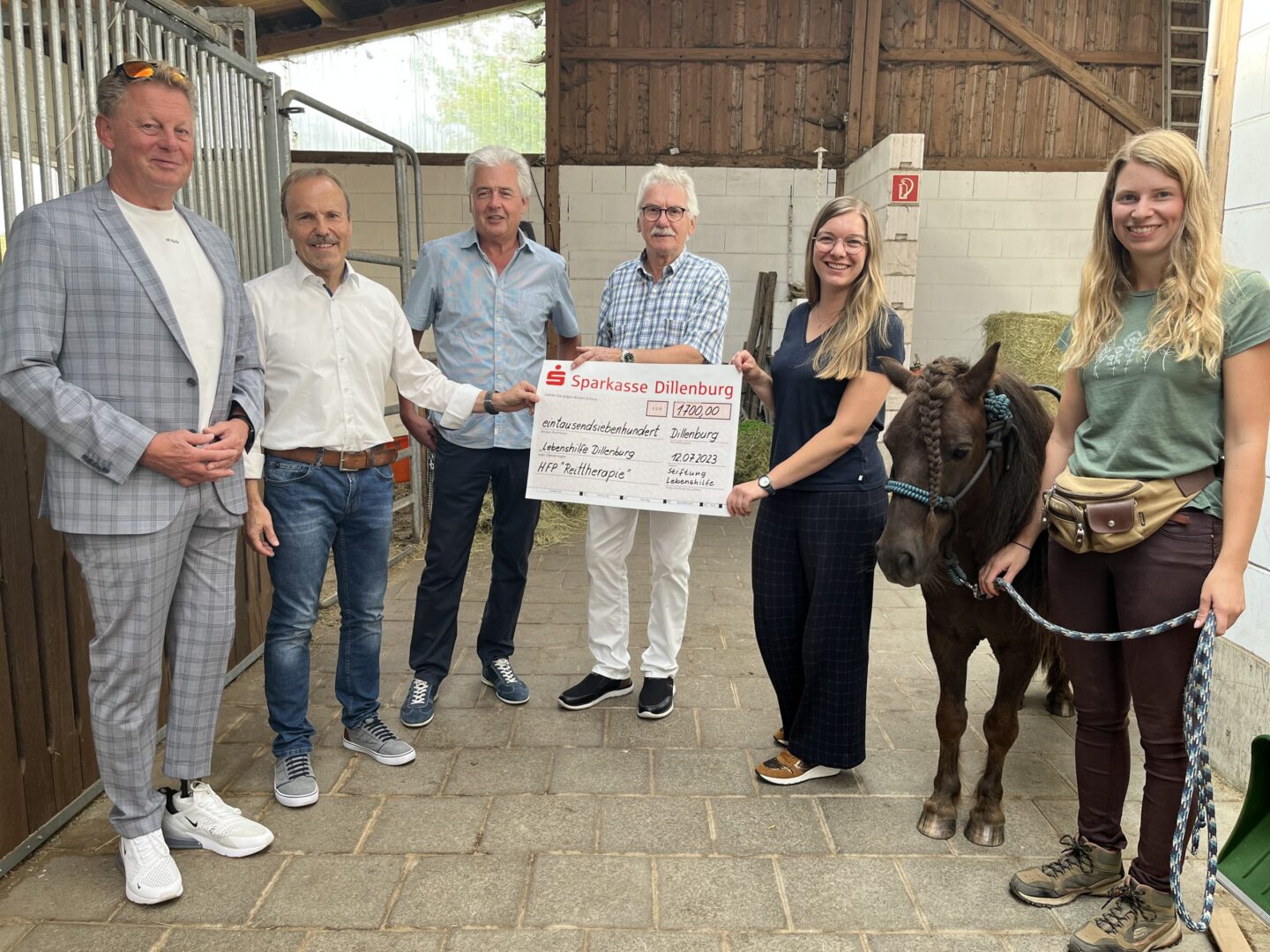 Scheckübergabe der Sparkasse Dillenburg für Reittherapie im Stall mit Pony