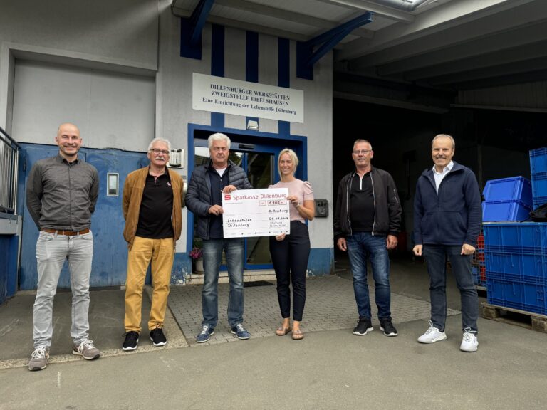 Sparkasse Dillenburg überreicht 1.200-Euro-Scheck an Lebenshilfe Dillenburg vor Werkstatt Eibelshausen.
