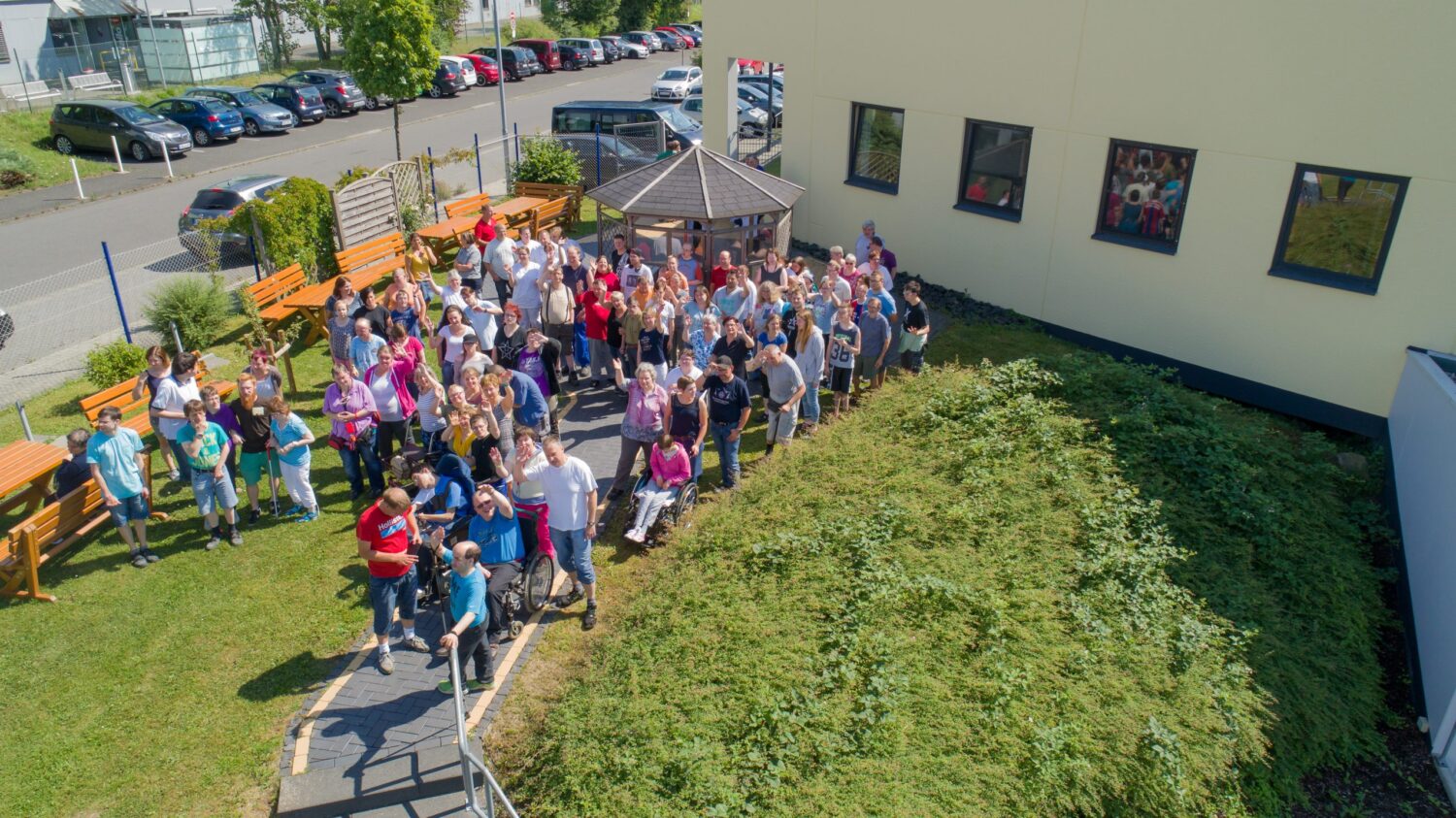 Werkstatt Flammersbach: Gruppenfoto beim Tag der offenen Tür im Innenhof, alle winken
